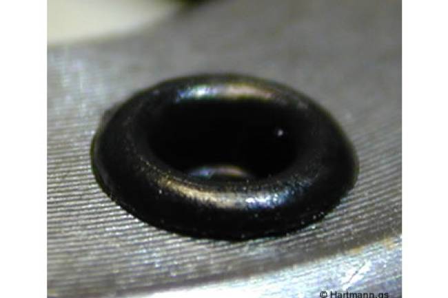 Ein Blech-Stanzteil wird durch einen heißverstemmten Pin in seiner Position fixiert.